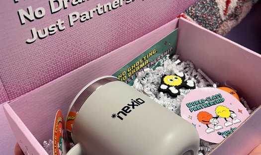 Pink Nexio partner kit box with a Nexio mug and “World-Class Partnership” stickers